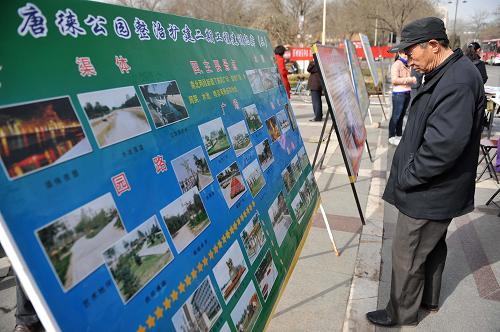 3月12日,市民在宁夏银川市街头观看园林宣传展板。 当日,宁夏银川市园林、绿化部门举行植树节宣传活动,向市民发放宣传单、现场讲解,宣传林业法规等知识。 新华社记者 王鹏 摄